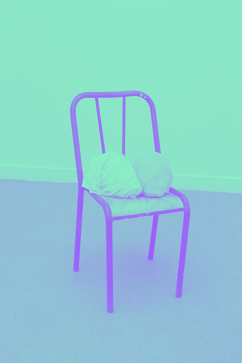 deux têtes emballées dans du linge posées sur une chaise