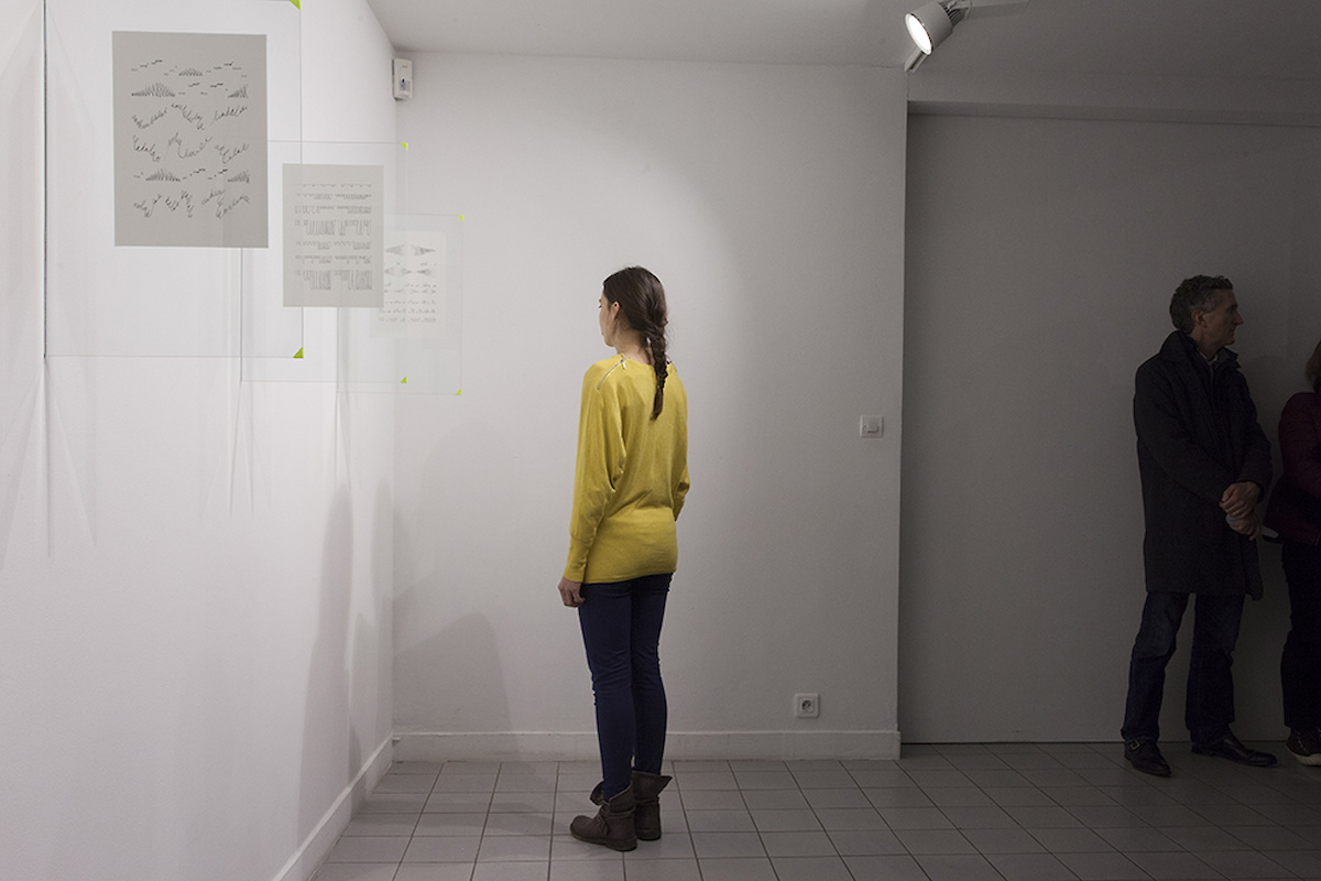 Une femme en pull jaune regarde le coin du mur