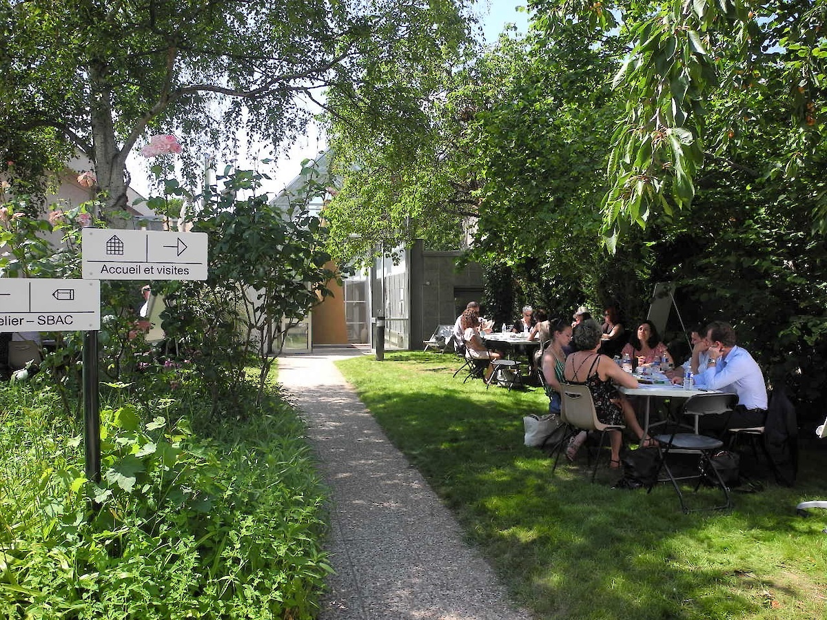 Des personnes attablées dans un jardin l'été