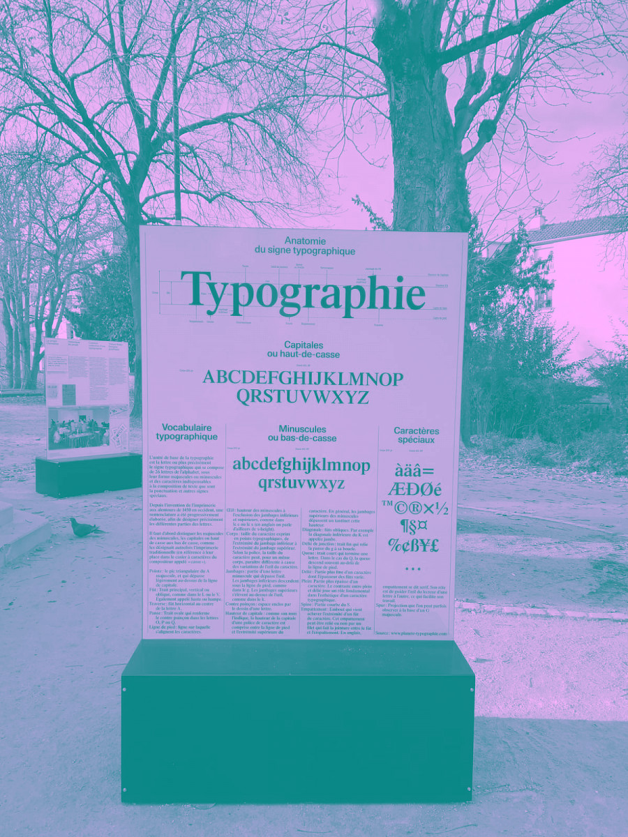 Un panneau rose dans un parc expliquant la typographie