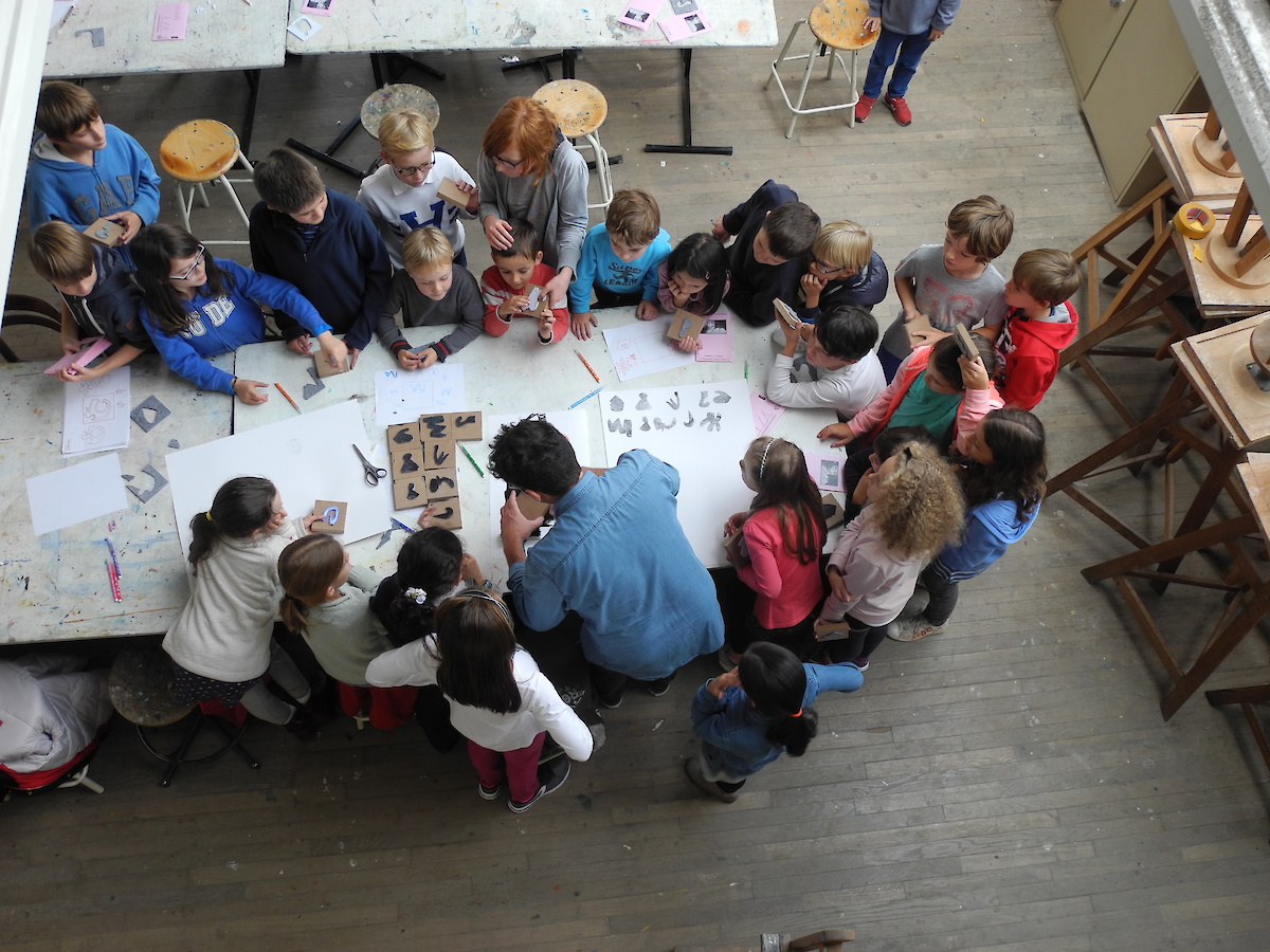 Des enfants dans un atelier artistique autour d'une table