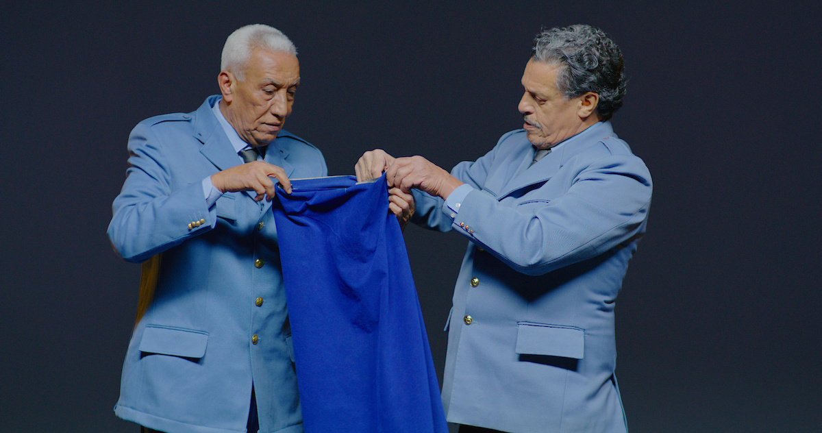 2 hommes en uniforme plient un drap, pliage de drapeau