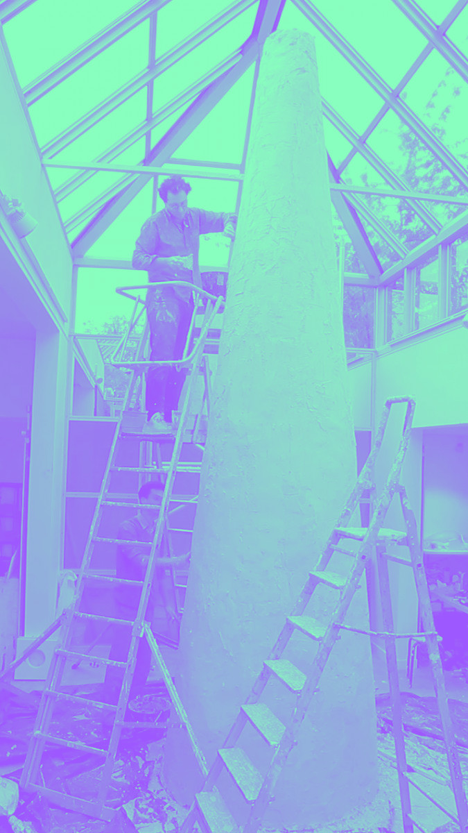 Un homme en haut d'une échelle construit une tour conique blanche
