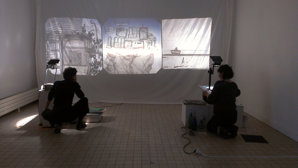 Deux personnes devant un écran projettant des images en noir et blanc