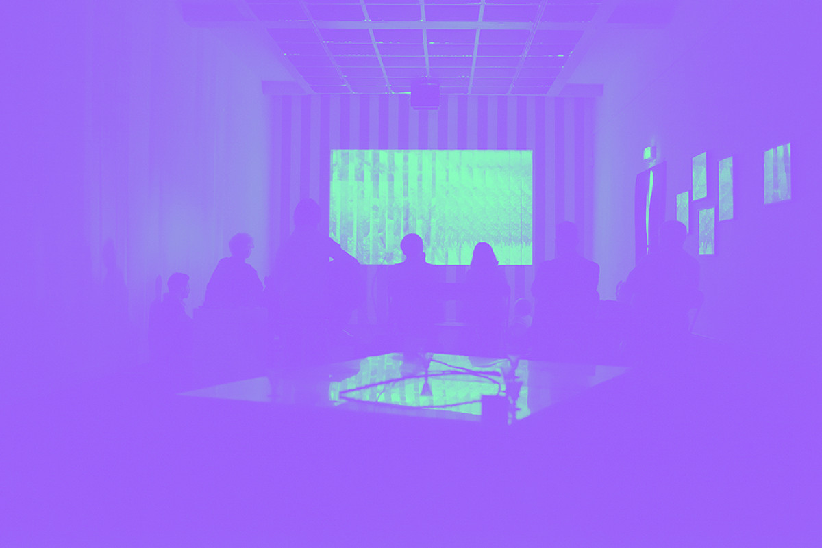 Une projection luminueuse sur écran au fond d'une salle noire