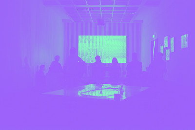 Une projection luminueuse sur écran au fond d'une salle noire