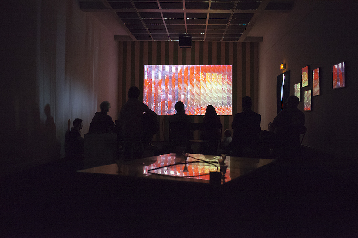 Une projection luminueuse sur écran au fond d'une salle noire