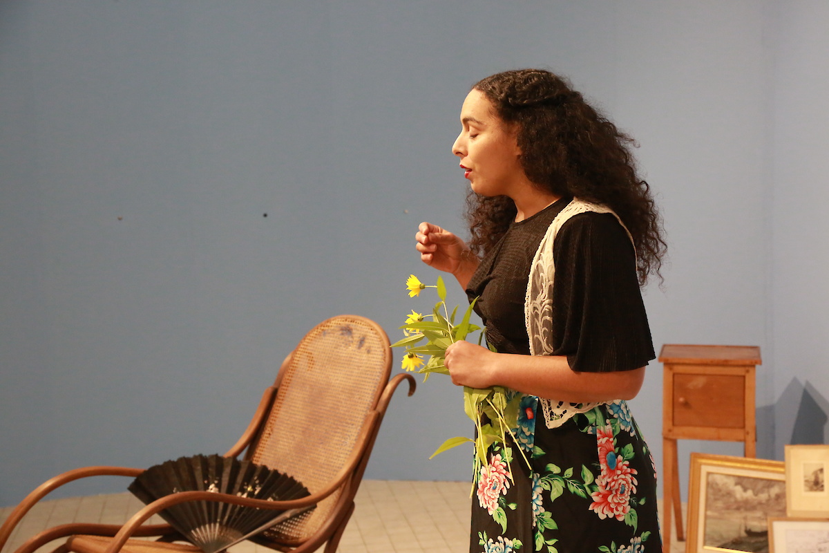 Une femme chante une fleur jaune à la main