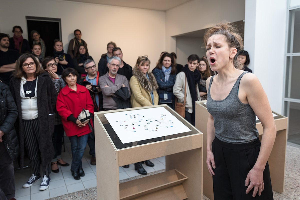 Une femme chante devant un public