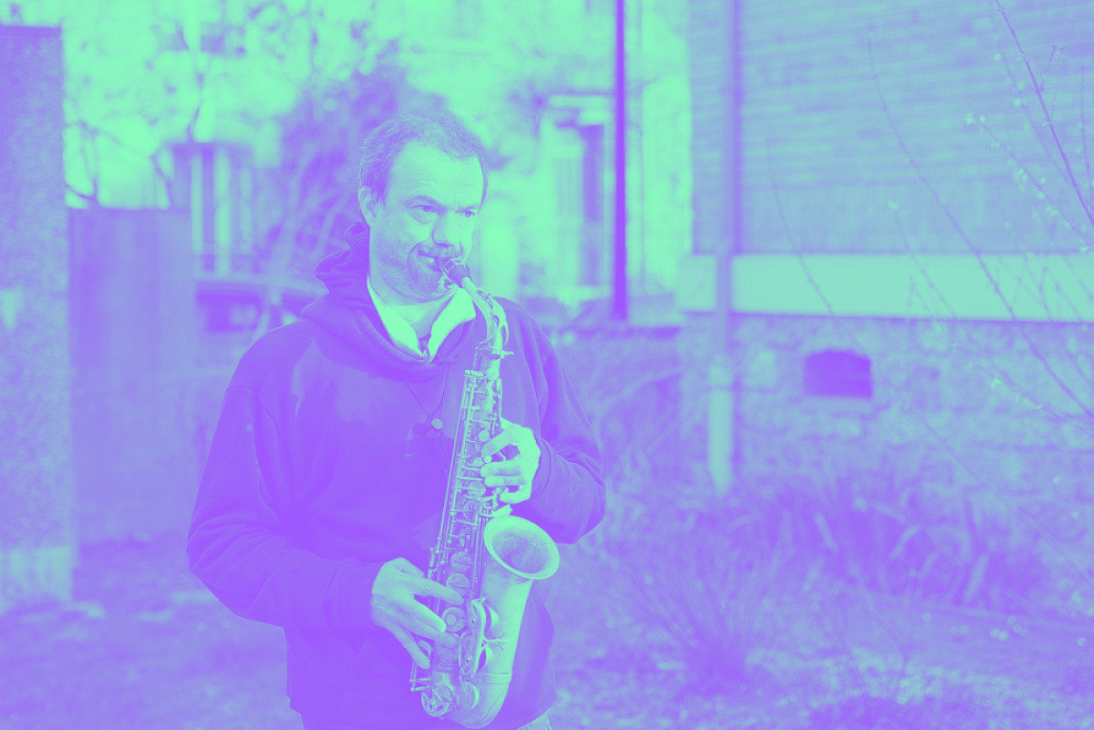 Un homme joue du saxophone dans un jardin
