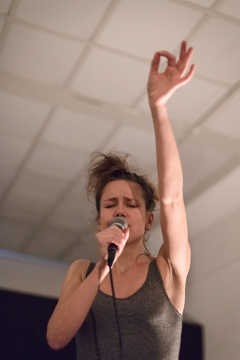 Une femme chante le bras levé