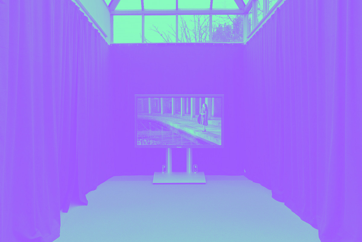 Un écran géant au fond d'un couloir de tentures noires