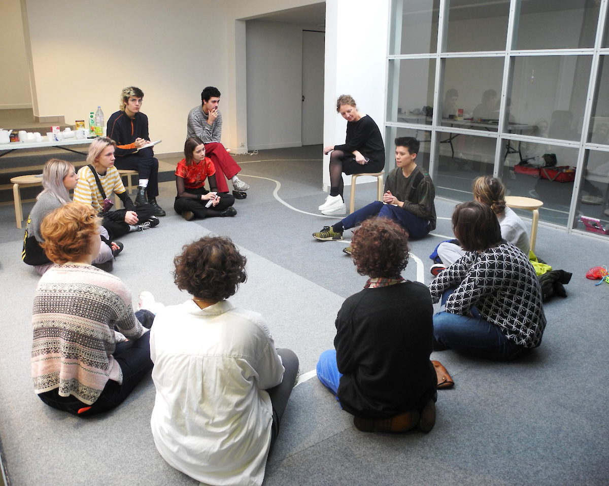 Atelier de création avec l'artiste Jay Tan et des étudiants en école d'art, personnes assises dans l'exposition, travail collectif