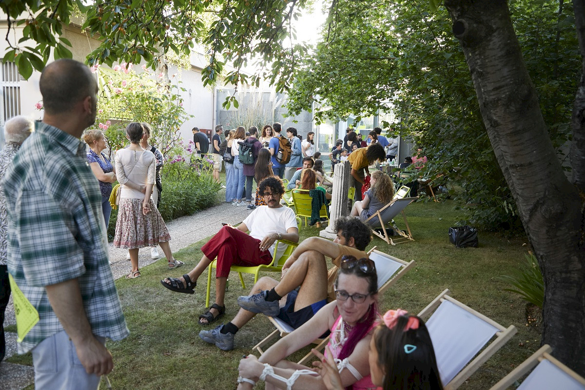 Jardin du centre d'art avec des transats et des personnes qui discutent